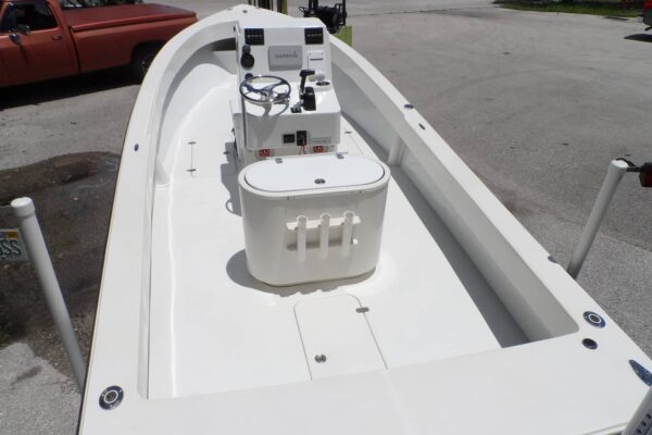 View from rear of the cockpit of Atlas Boatworks 23F center console fishing boat. Steering wheel on the left and throttle lever on the right. White gelcoat. Livewell in foreground.