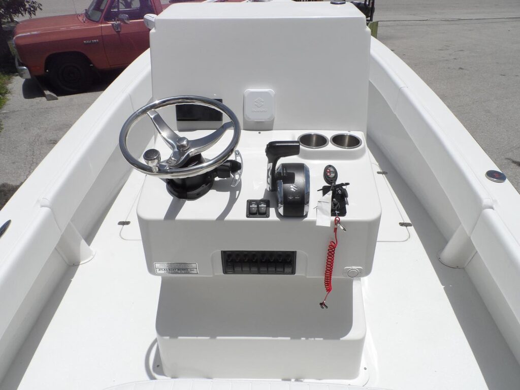 Console of Atlas Boatworks 23F center console fishing boat. Steering wheel on the left and throttle lever on the right. White gelcoat.