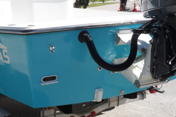 Stern view of a blue Atlas Boatworks 23F that shows the deadrise. White porta bracket and outboard are installed.