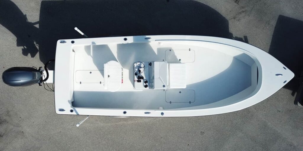 An overhead view of an Atlas Boatworks 23F center console fishing boat on a trailer with a white deck and 3 hatches.