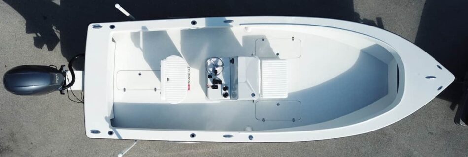 An overhead view of an Atlas Boatworks 23F center console fishing boat on a trailer with a white deck and 3 hatches.
