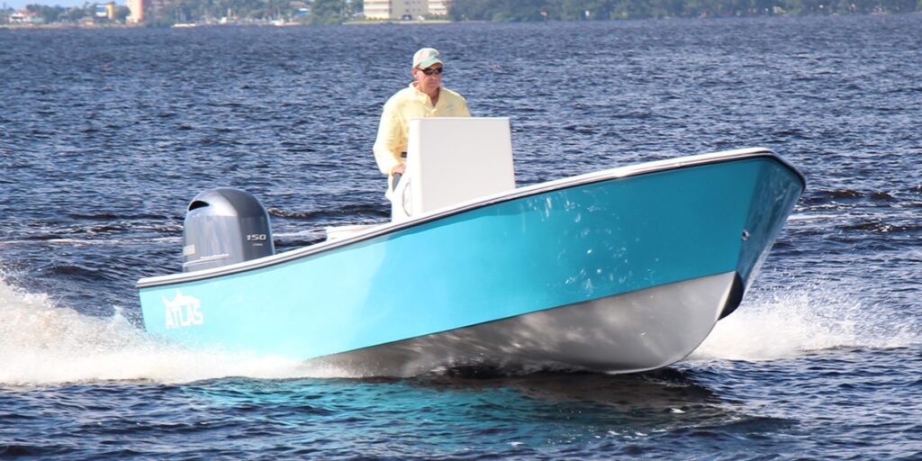 Side view of a boston whaler blue Atlas Boatworks 23F center console fishing boat running in choppy water. 150hp yamaha outboard engine on the back.