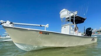 Side view of tan Atlas Boatworks 23F center console fishing boat at anchor. It has a half tower installed with 2nd station up top.
