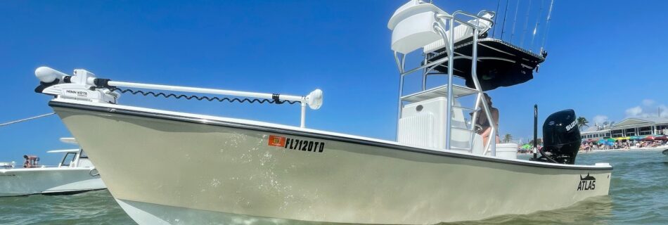 Side view of tan Atlas Boatworks 23F center console fishing boat at anchor. It has a half tower installed with 2nd station up top.