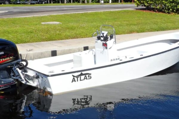 Side view of Atlas Boatworks 23F center console fishing boat tied to a seawall. 200hp yamaha vmax engine on the back.