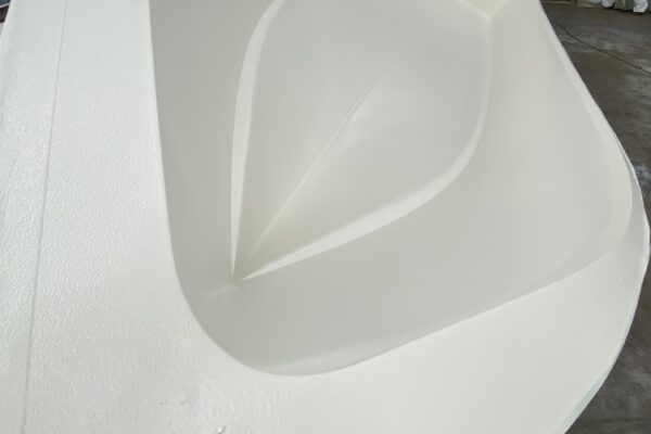 A picture of a white boat hull in the mold from the bow back.