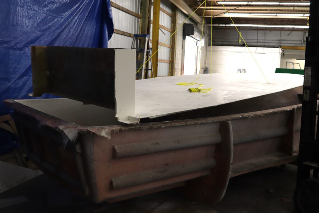 A boat deck hangs above a boat mold