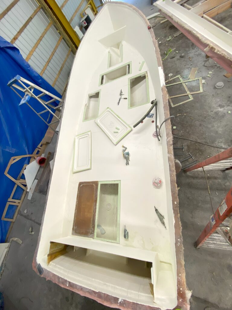 Hatch rings rest on the deck of a boat under construction