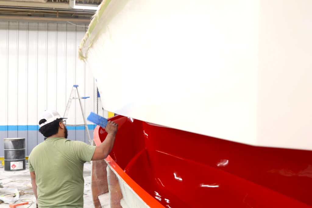 A worker bangs on the hull looking for air bubbles