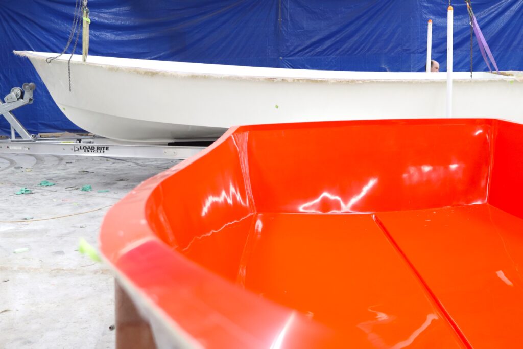 A boat mold sits in front of a boat hull