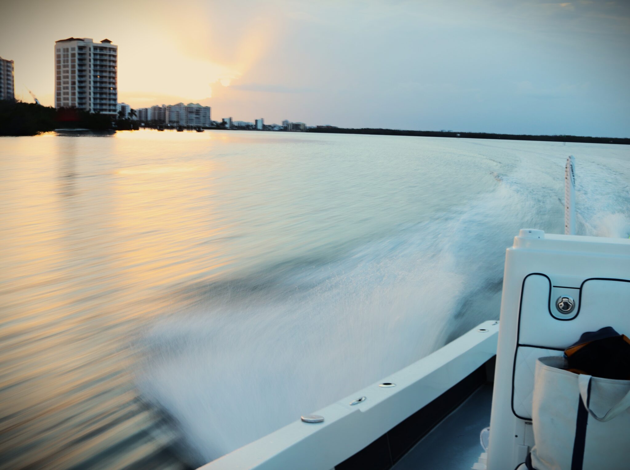 Atlas Boatworks 23F bay boat sprays water up off the side at sunset