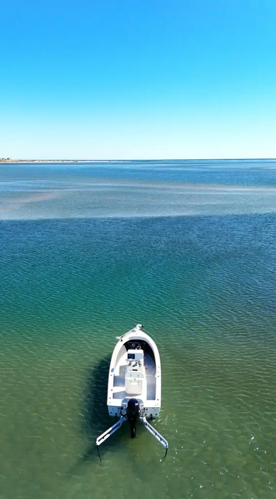 Atlas Boatworks 23F bay boat anchored near a channel