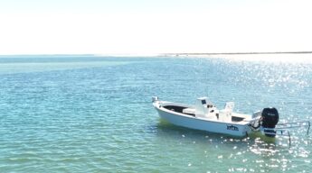 Atlas Boatworks 23F Bay Boat sits in blue-green water on a sunny day