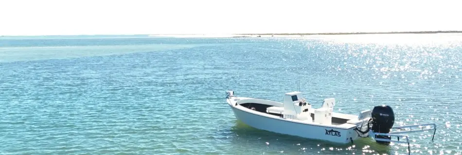 Atlas Boatworks 23F Bay Boat sits in blue-green water on a sunny day