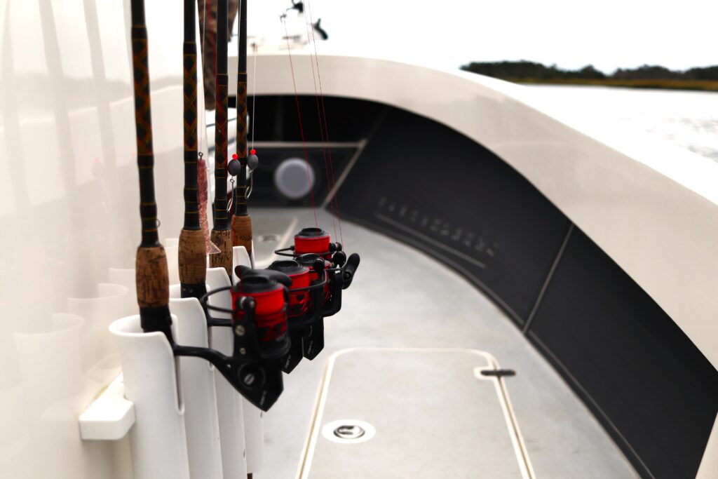 Four fishing rods stand in holders on the console of the Atlas Boatworks 23F bay boat