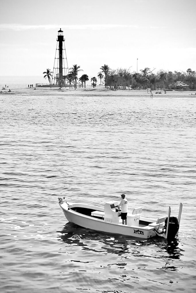 an Atlas Boatworks 23F bay boat idles in front of the Sanibel, FL lighthouse